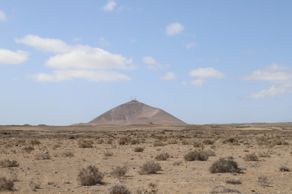 Lanzarote: Sandböden mit Vulkankrater im Hintergrund