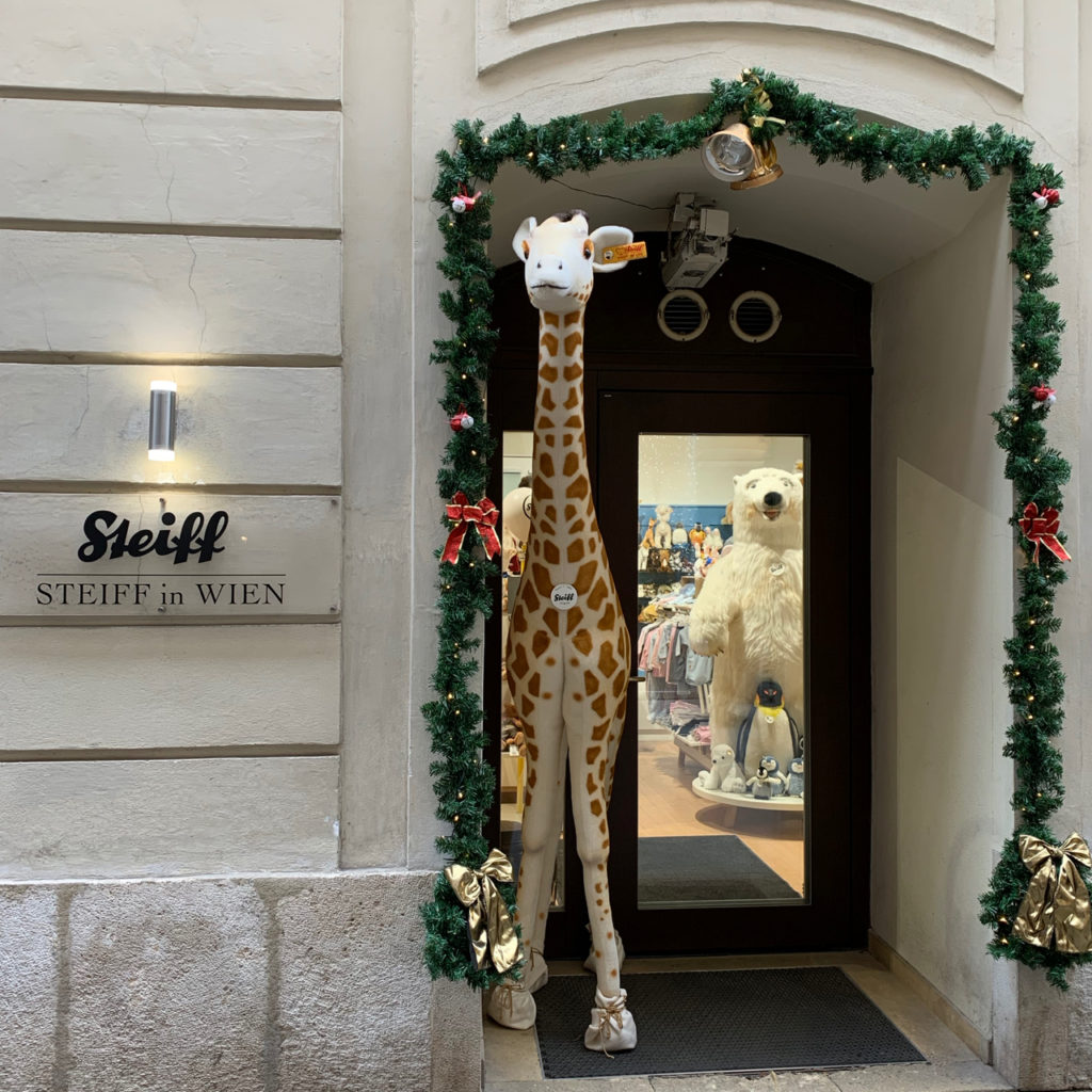 Schaufenster Wien zur Weihnachtszeit: Steiff-Geschäft mit etwa 2 Meter großer Giraffe von Steiff im Eingang